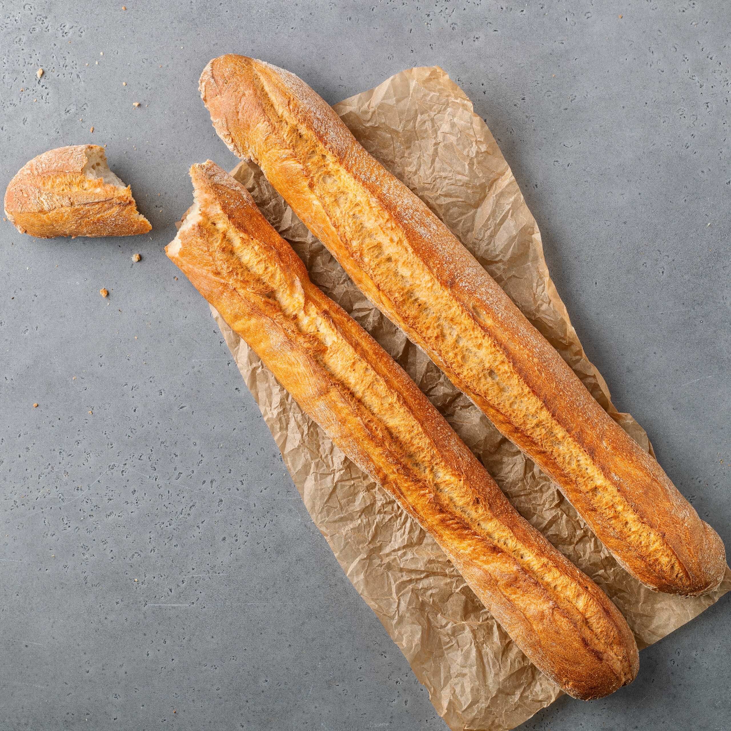 Baguette naturell - två ljusa baguetter på ett bakplåtspapper | Dahls Bageri