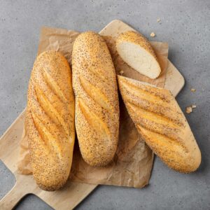 Halvbaguette vallmo - 3 st bröd på en träskärbräda | Dahls Bageri